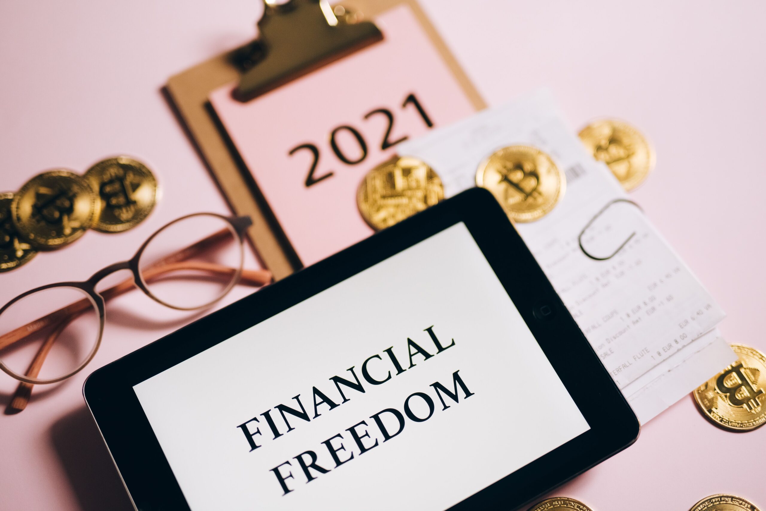 HOME Tablet displaying 'Financial Freedom' surrounded by bitcoins and 2021 planner, symbolizing cryptocurrency potential.